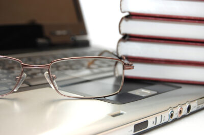 Eyeglasses and books on the laptop